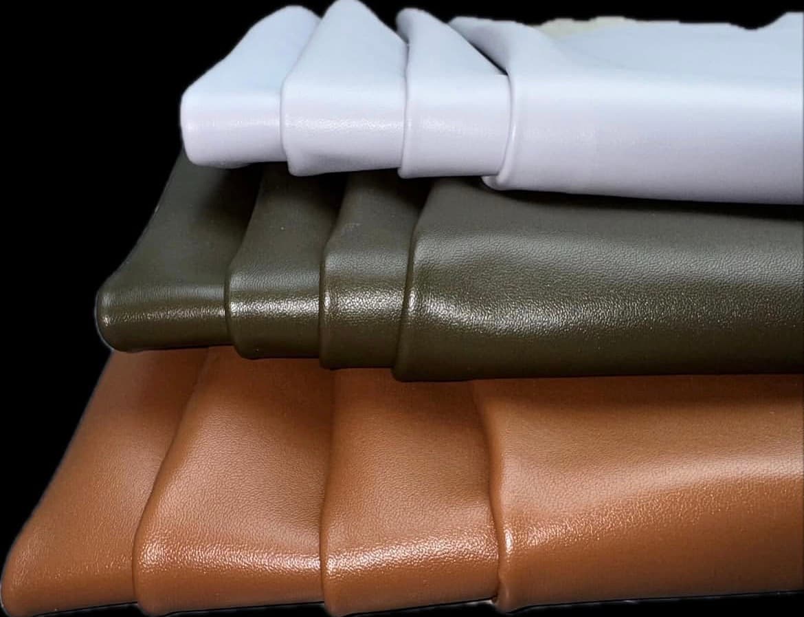 Rolled leather articles arranged as a material table.