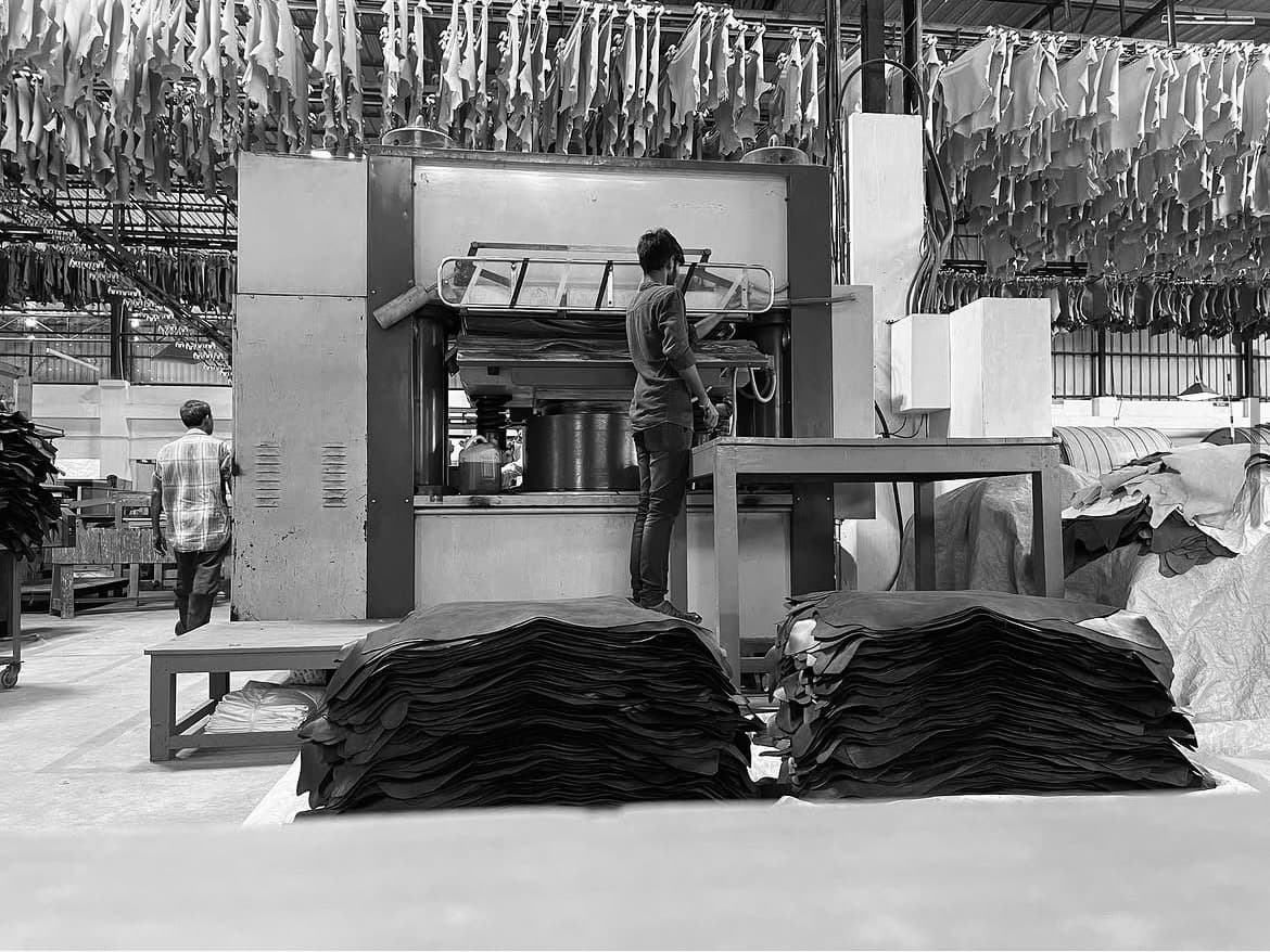 Workshop inspection beside a leather production floor.